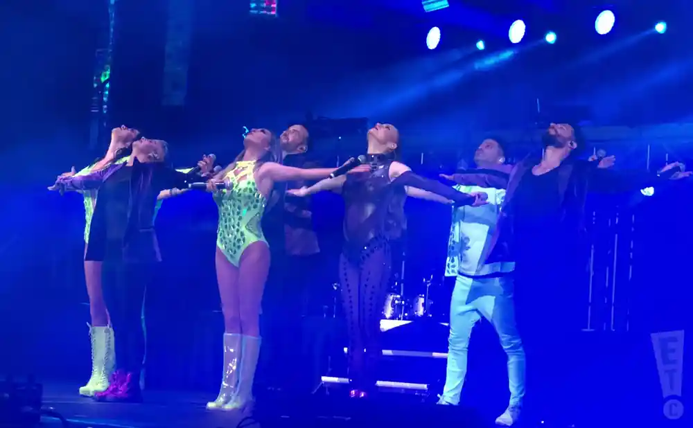 the 90s pop tour members on stage posing in blue light