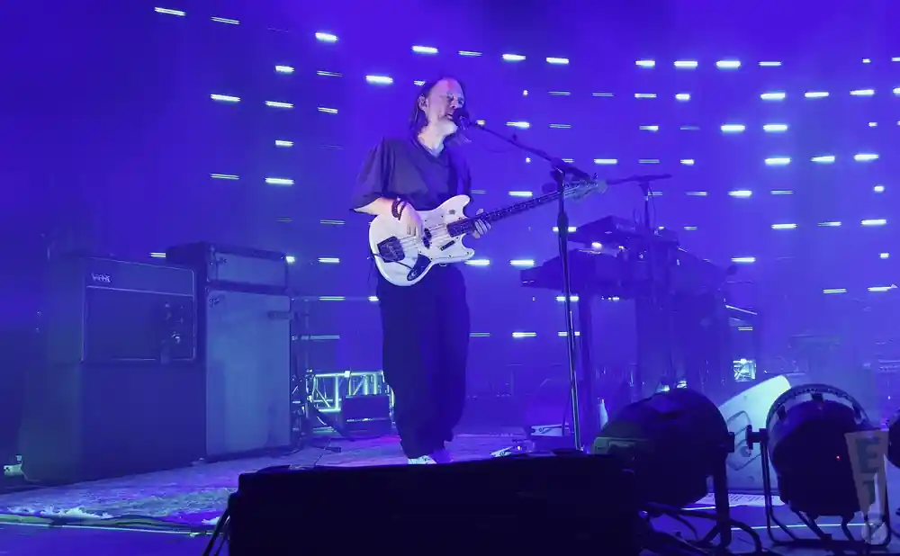 the smile playing the bass while singing live