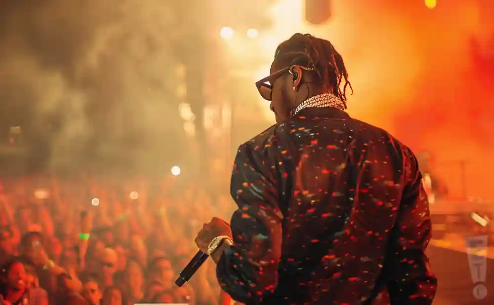 a rear view photo of future performing a concert on stage to a lively audience