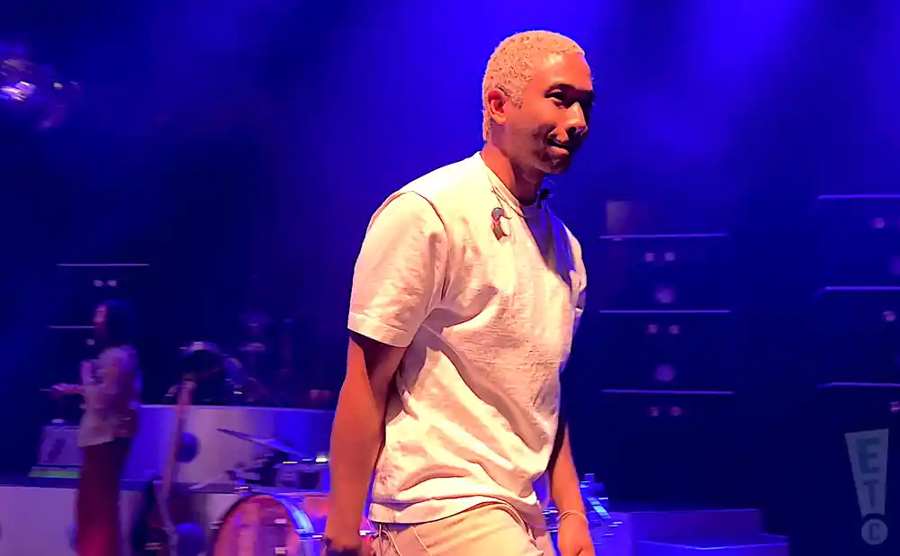 toro y moi performing in white shirt under blue lights