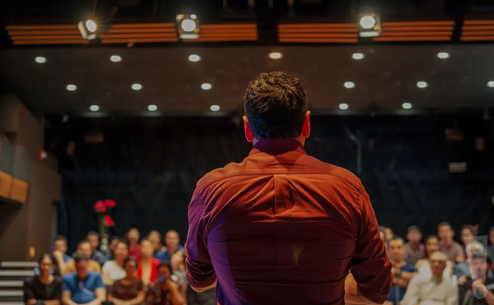 photograph of dr. cesar lozano giving a lecture of a full audience of people in an indoor theater