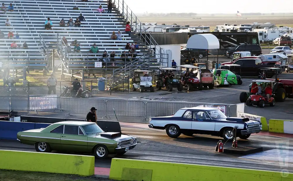 two cars at the starting line of a race during the day at tx2k25