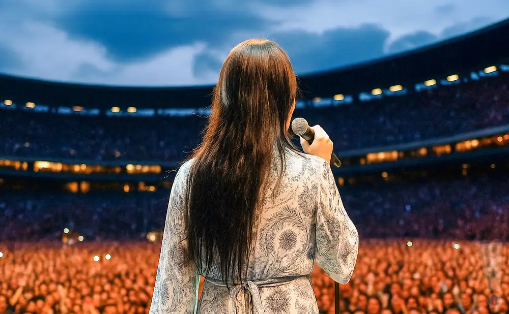 a rear view image of adore delano performing live on stage