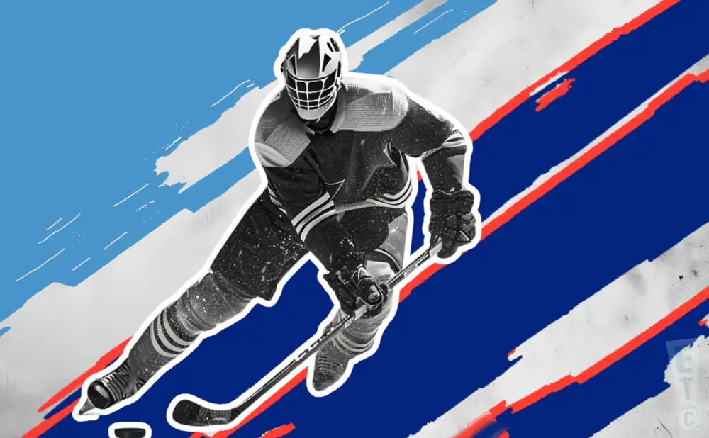 an anchorage wolverines ice hockey player about to hit the puck