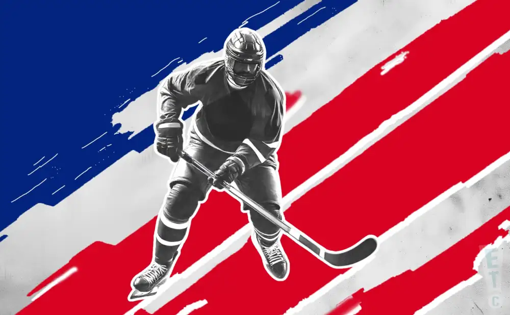 a maine nordiques ice hockey player about to hit the puck