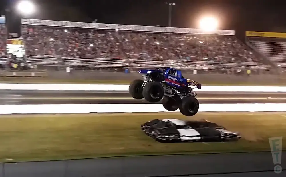a picture of a monster truck jumping in the night of fire and destruction 2015