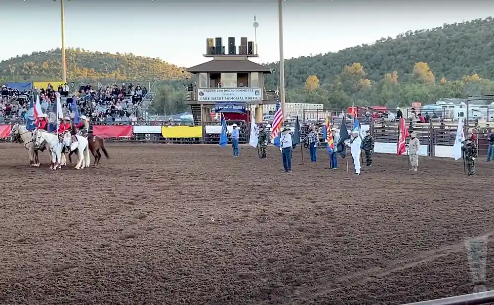 people holding flags in the arena for the 2022 gary hardt memorial rodeo.