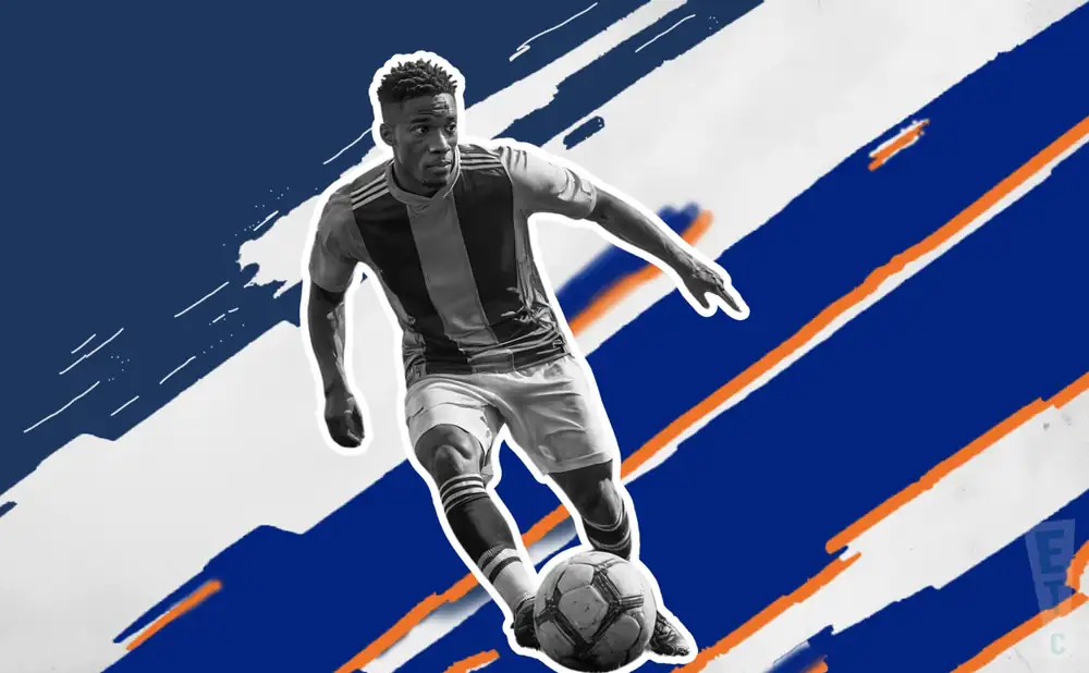 a orange county sc soccer player kicking the ball down field