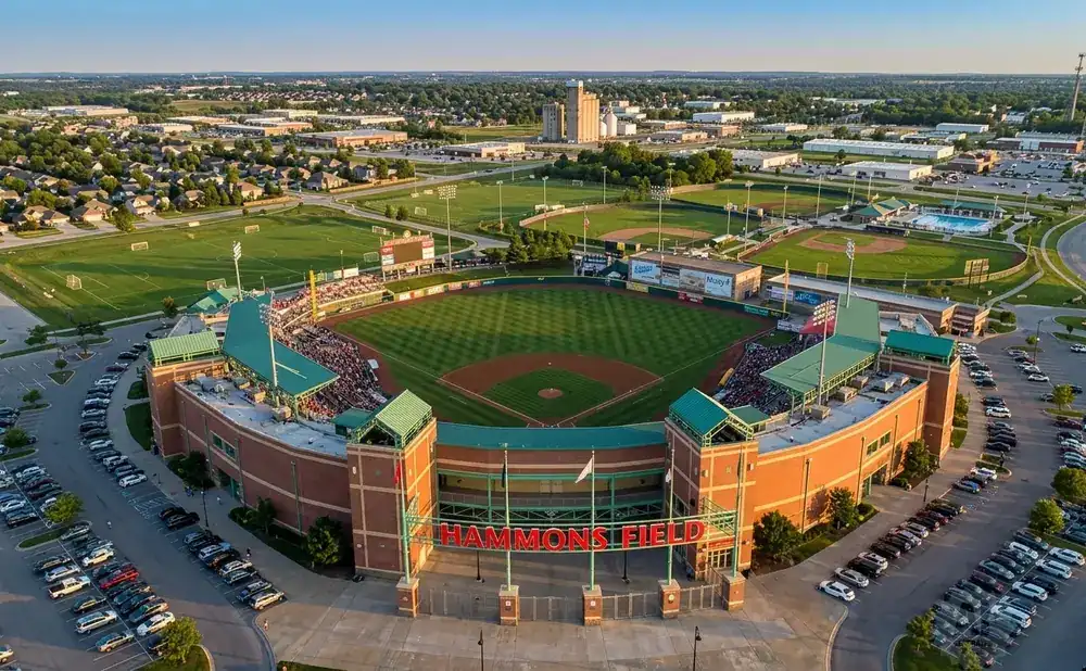 Aerial view of Hammons Field baseball stadium, with a baseball diamond, packed stands, and surrounding parking lots.