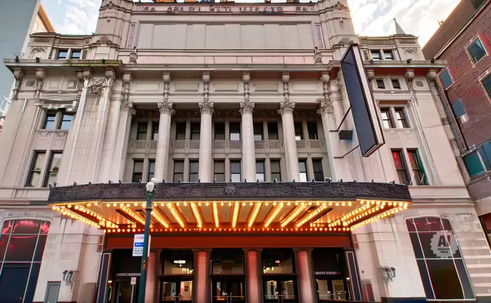 Grand theater entrance with illuminated marquee and ornate classical architecture.