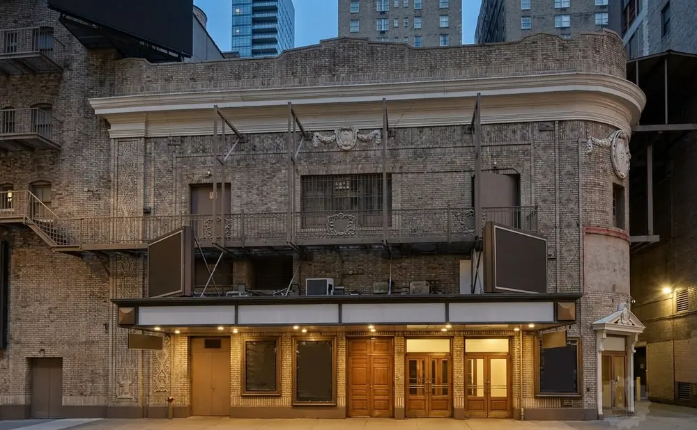 A brick theater facade with a marquee and lighted entrance.