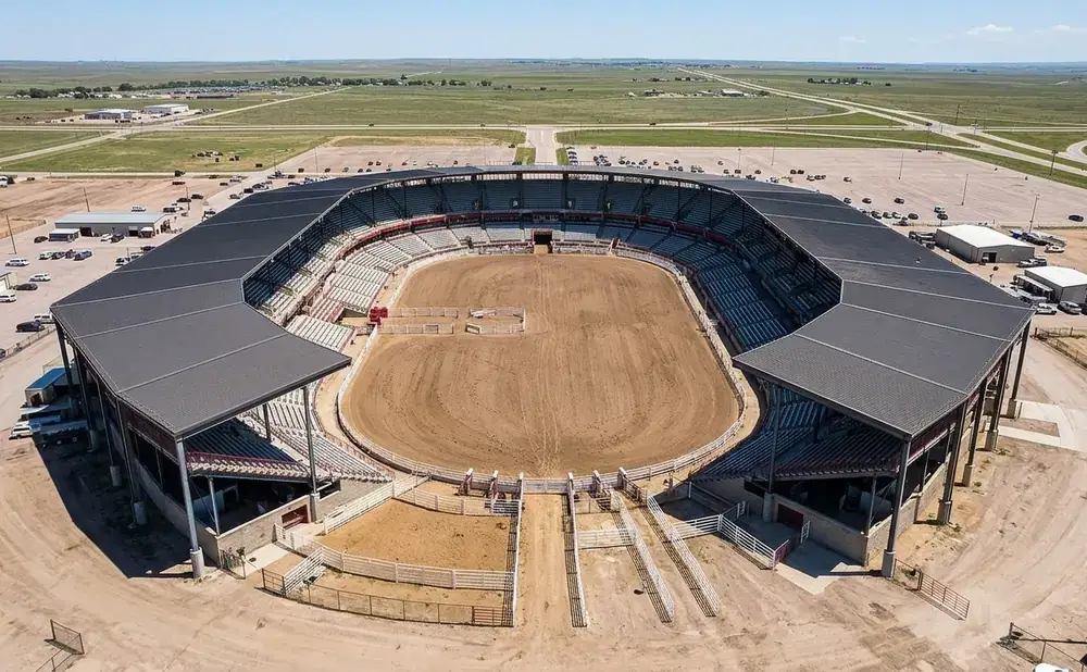 Aerial view of a rodeo arena with grandstands and a dirt arena.