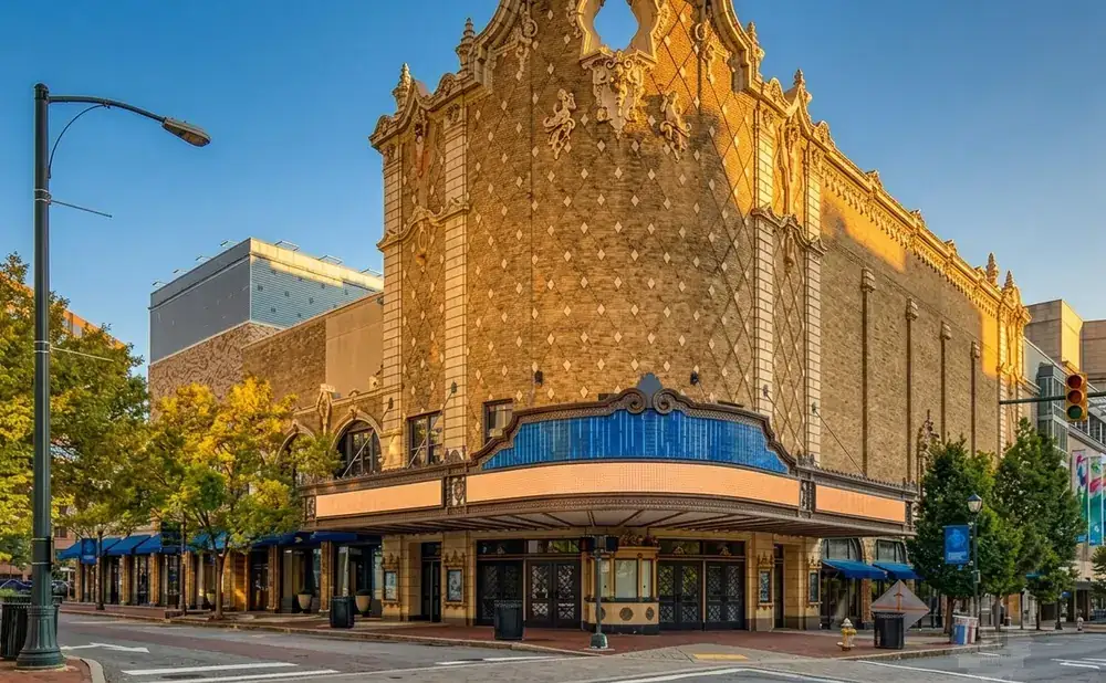 An ornate vintage theater facade with brick and decorative elements, bathed in golden sunlight.