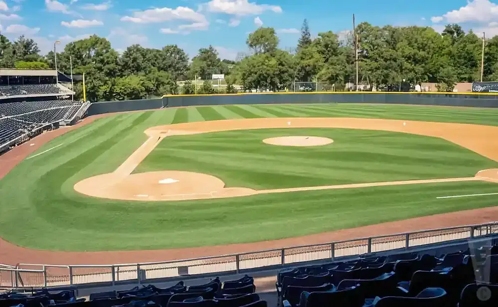 A baseball stadium under a blue sky with fluffy clouds.