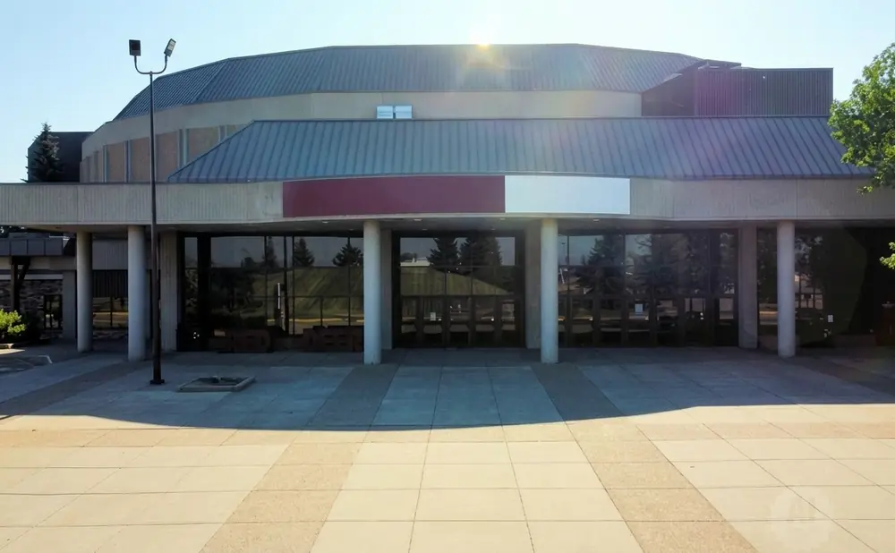 Modern building with a large glass entrance and a curved roof.