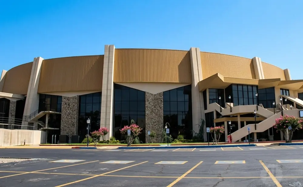 Modern building with large windows and beige and gold panels, set against a clear blue sky.