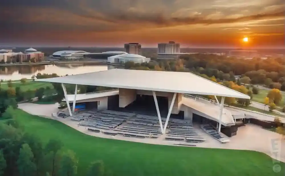 Aerial sunset view of an outdoor amphitheater with tiered seating and a large, modern canopy.