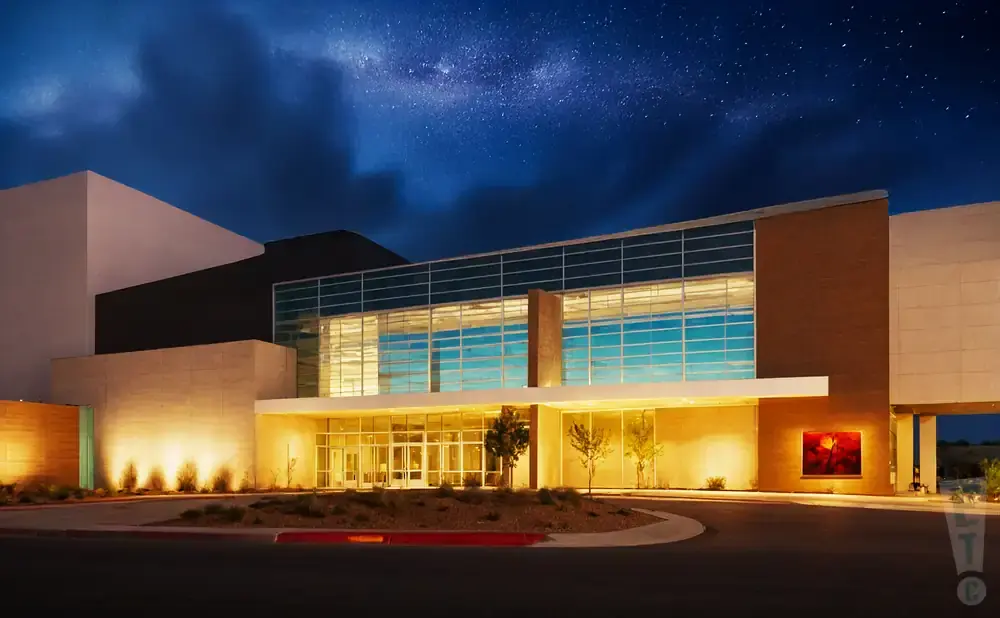 Modern building with large glass windows at night under a starry sky.