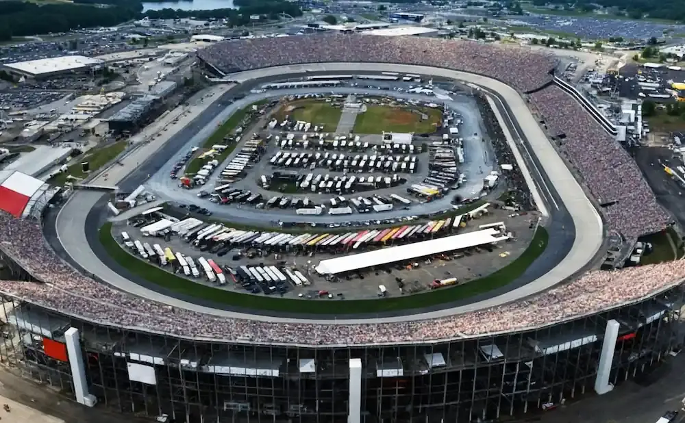 Aerial view of a crowded NASCAR racetrack with stands full of spectators.