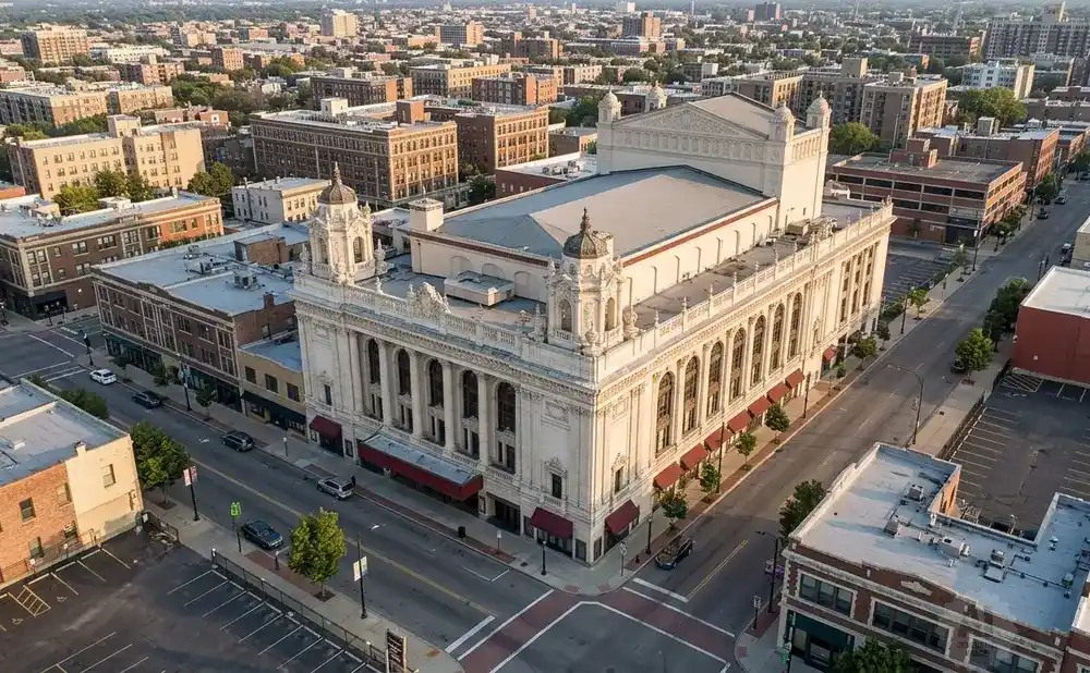 Aerial view of a large, ornate theater surrounded by city buildings and streets.
