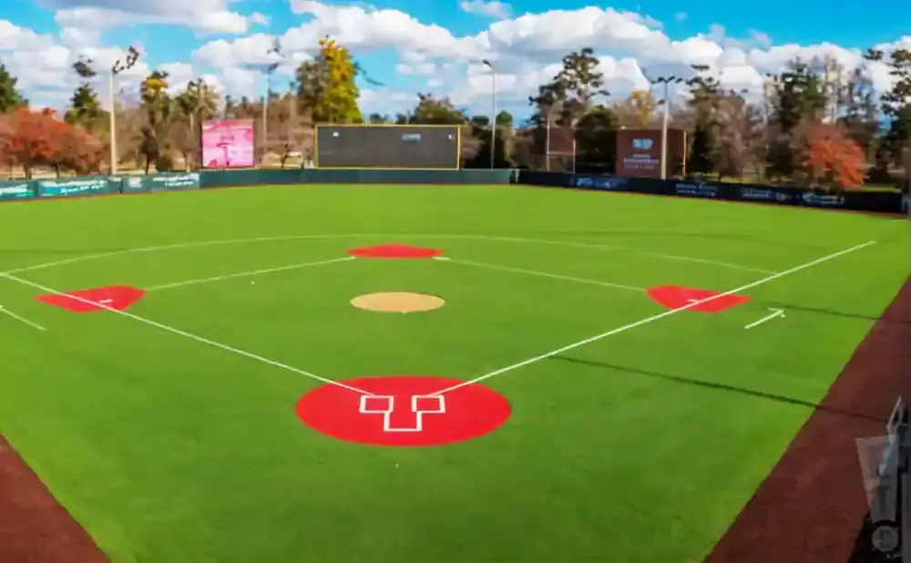 A baseball field from an aerial view, showing the green grass, red bases, and a pitcher's mound.