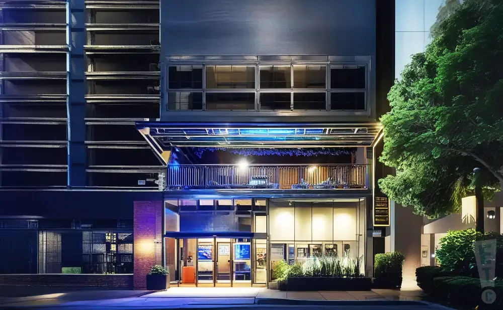 A modern building with glass doors and windows, illuminated at night.