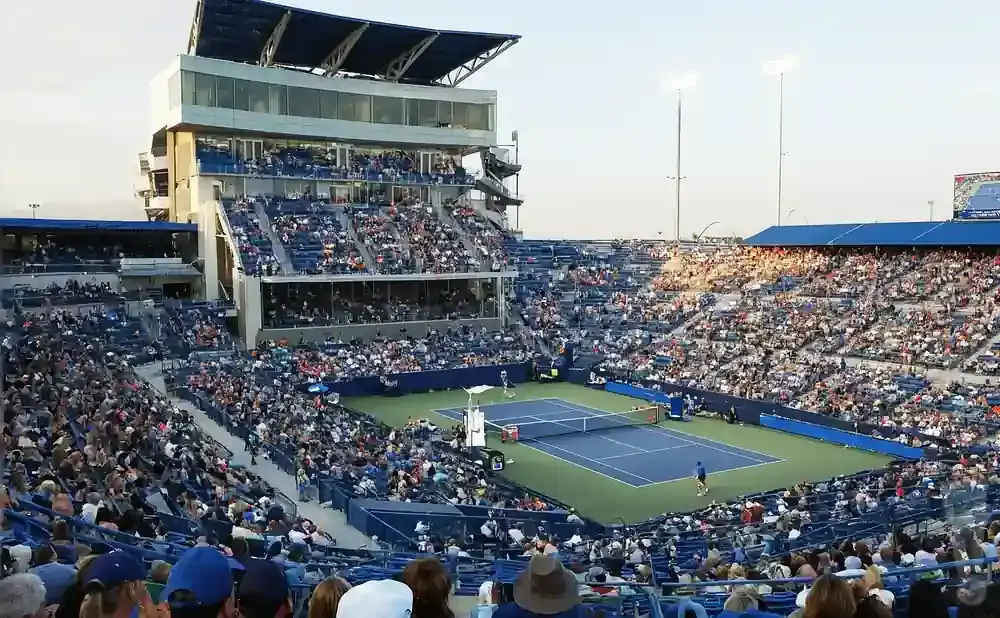 A tennis match in a stadium with spectators in the stands.