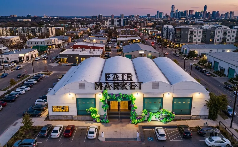 An aerial view of Fair Market at dusk, with a city skyline in the distance.