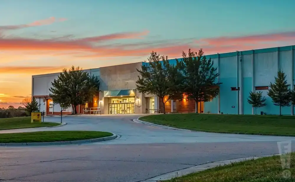 Modern building at sunset with a colorful sky.