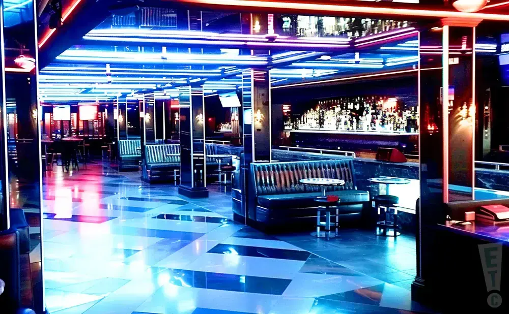 A modern nightclub with neon lights, leather booths, and a well-stocked bar.