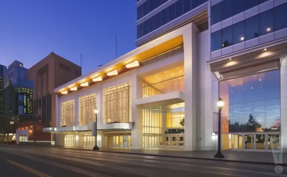 Modern glass building with large windows at dusk, reflecting the colorful sky.