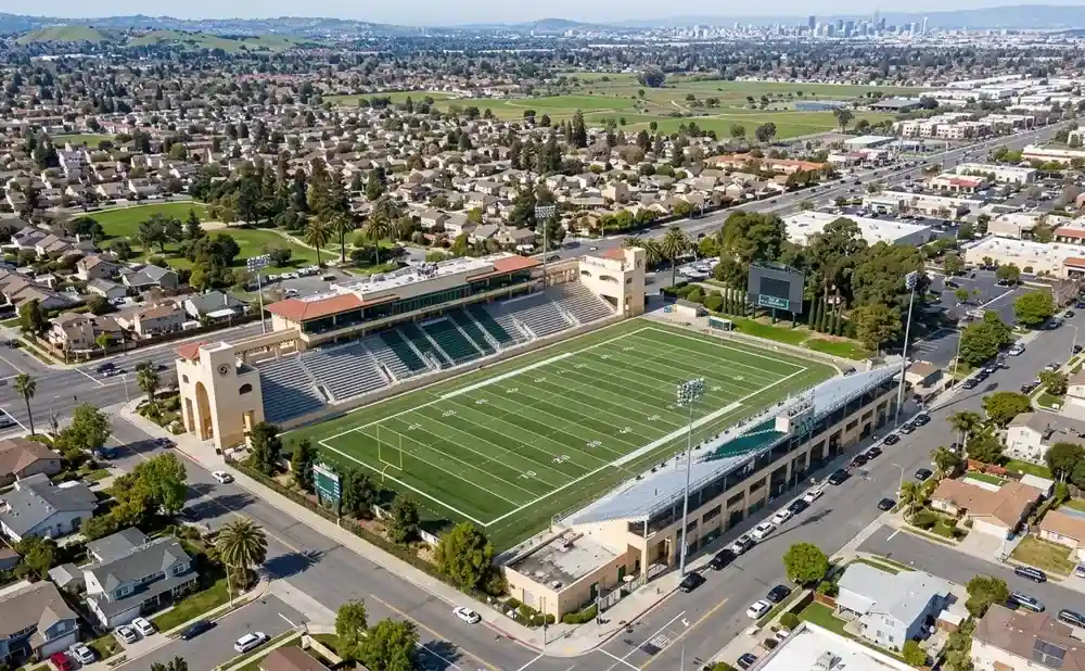 Aerial view of a football stadium surrounded by residential homes and businesses.
