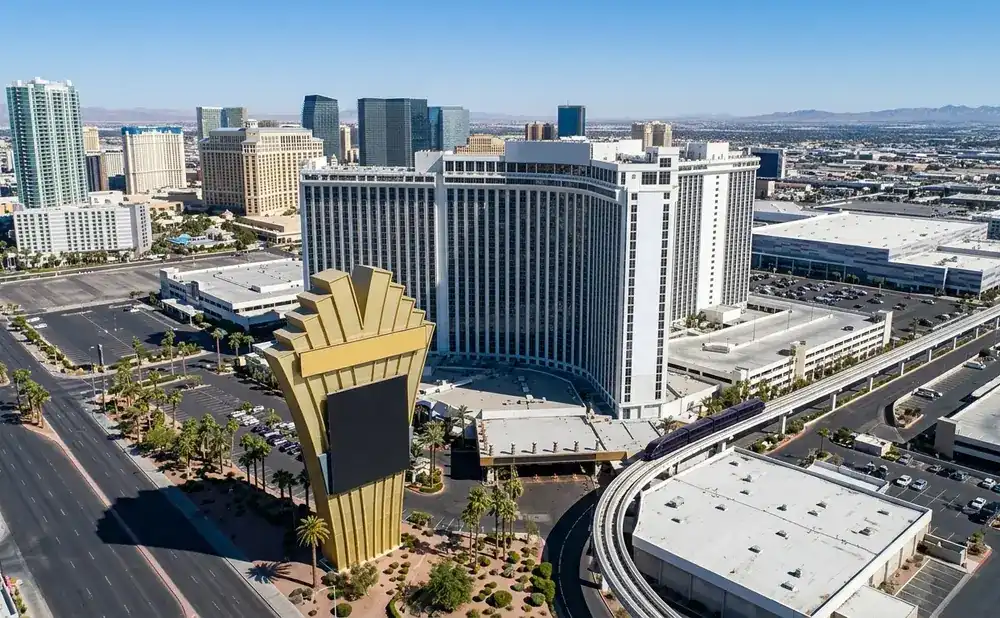 Aerial view of a large hotel and casino on the Las Vegas Strip with a monorail passing by.