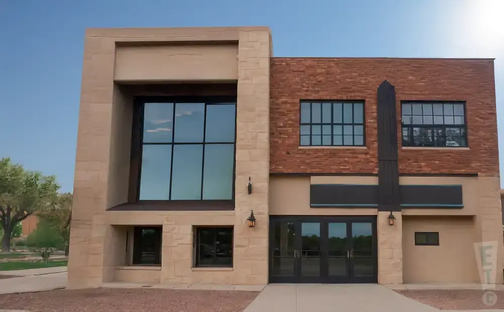 Modern building with tan stone accents, red brick, and large windows.