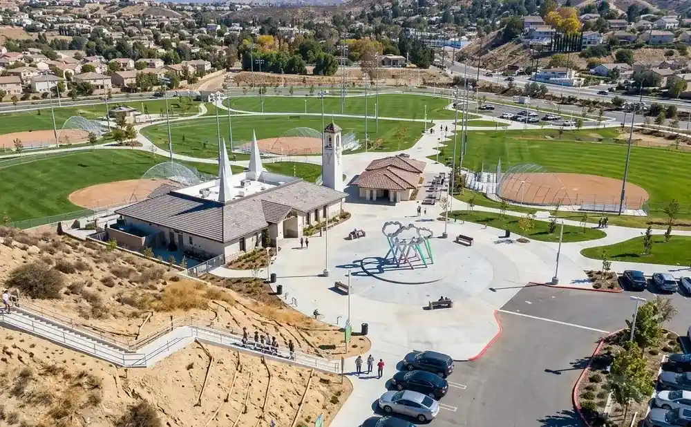 Aerial view of a park with baseball fields, a playground, and a large staircase leading up a hill.
