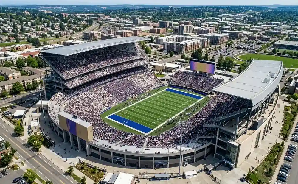 Aerial view of Husky Stadium filled with fans watching a football game.
