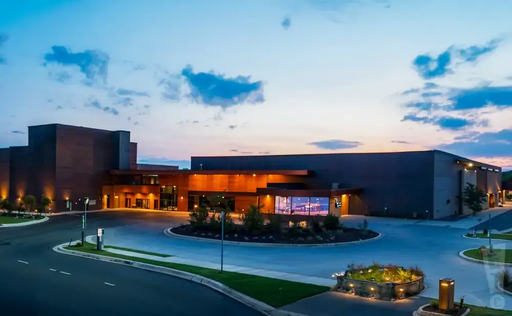 Modern buildings with wooden accents and lit windows under a twilight sky.