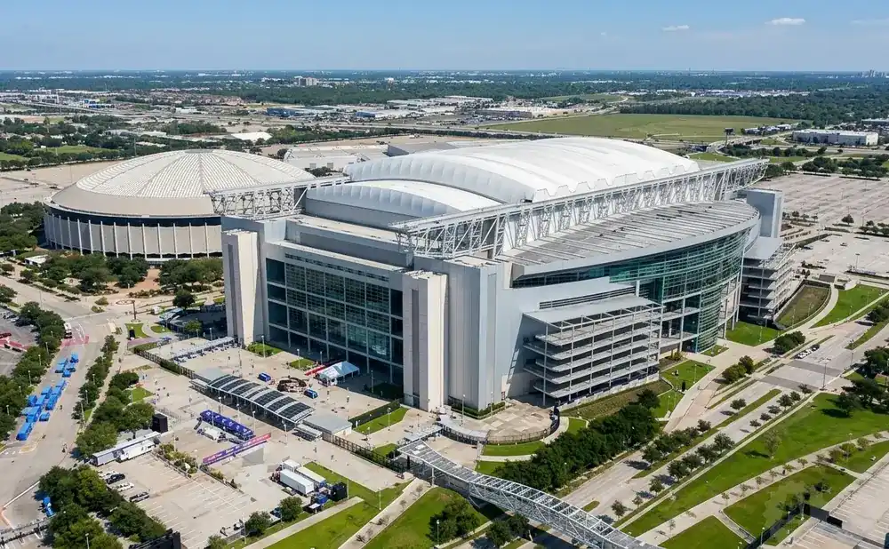 Aerial view of NRG Stadium and the adjacent Astrodome in Houston, Texas, on a sunny day.