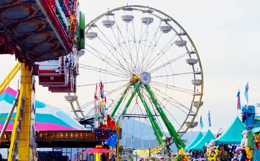 A Ferris wheel and carnival rides at a fair.