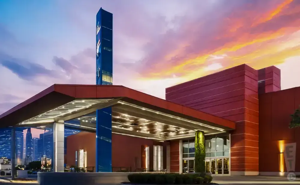 Modern red building with a tall blue tower and colorful sunset sky.