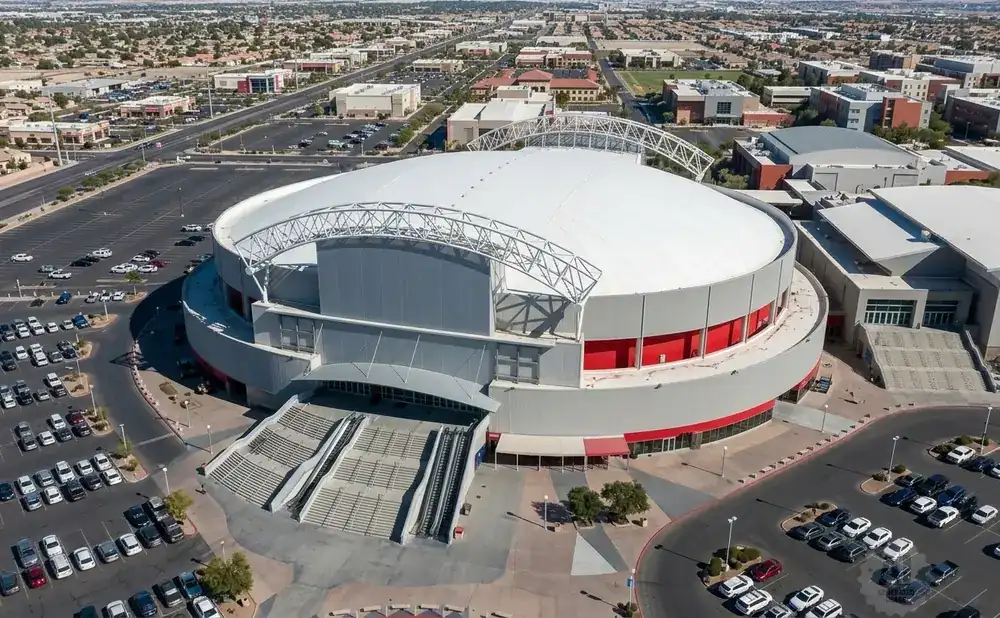 Aerial view of a large domed arena complex with surrounding parking lots and buildings.