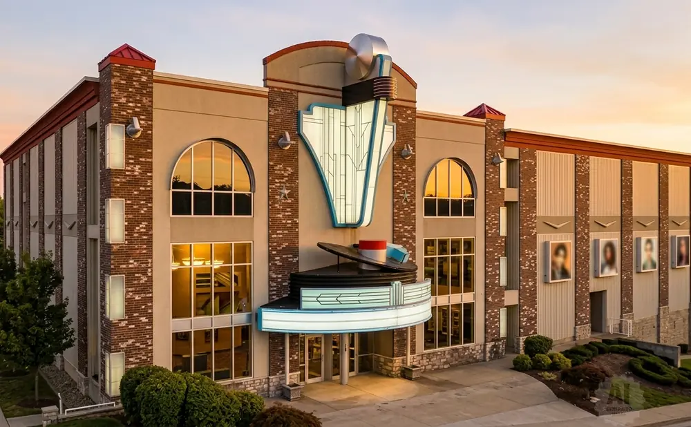 Art deco theater with a record player marquee at sunset.