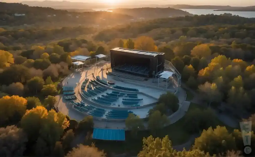 Aerial view of an outdoor amphitheater nestled among trees at sunset.