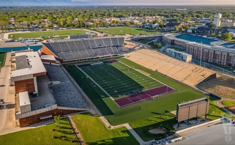 Aerial view of a football stadium with a green field, grandstands, and surrounding buildings.