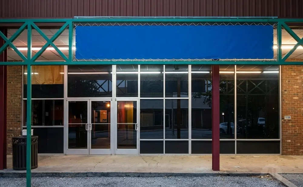 A storefront with a large blue banner above the glass entrance doors.
