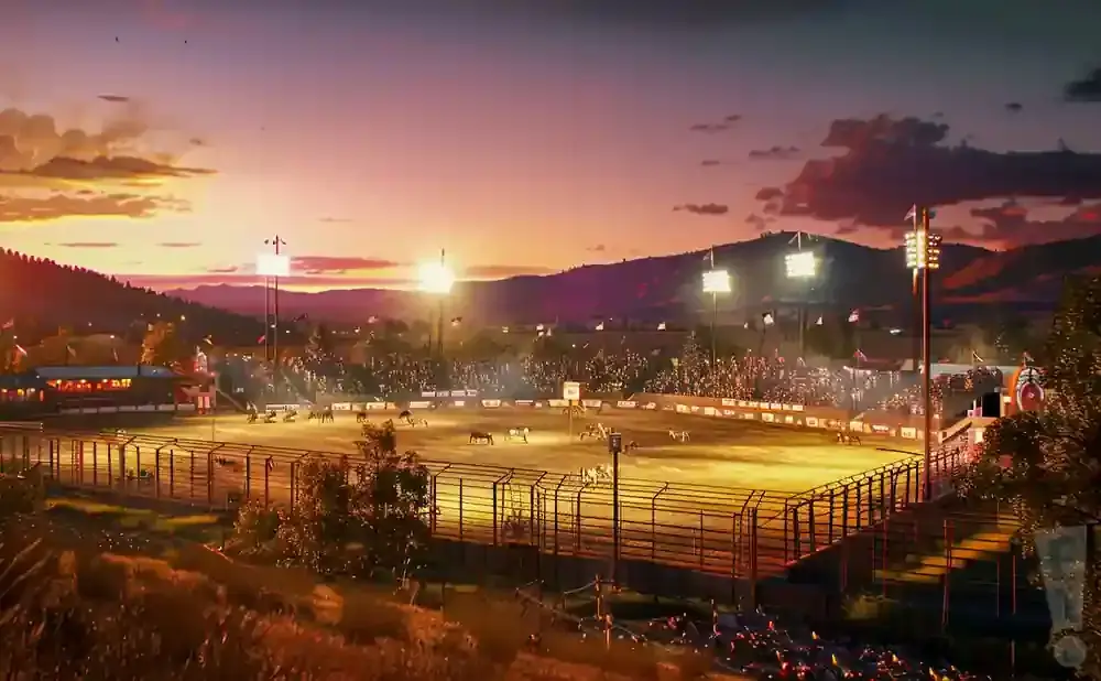 A rodeo arena at sunset with a crowd in the stands.