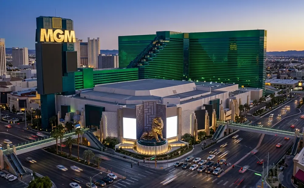 MGM Grand Las Vegas with its iconic lion statue and green buildings at dusk.