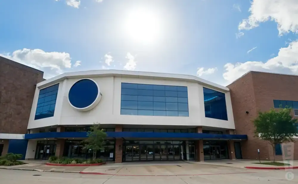 Modern brick building with a white, octagonal facade featuring large blue windows and a circular window.