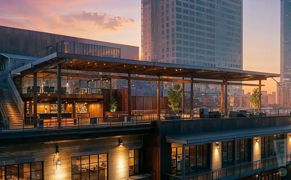 Rooftop bar and restaurant with city skyline at sunset.