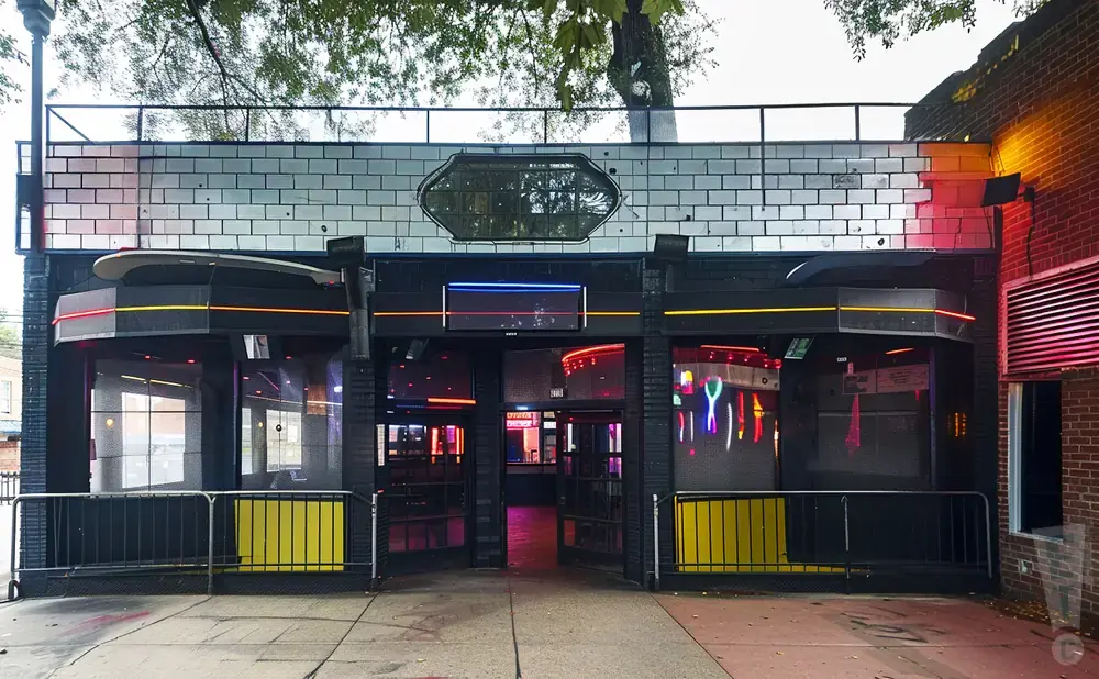 Exterior of a nightclub with black facade, neon lights, and patterned windows.